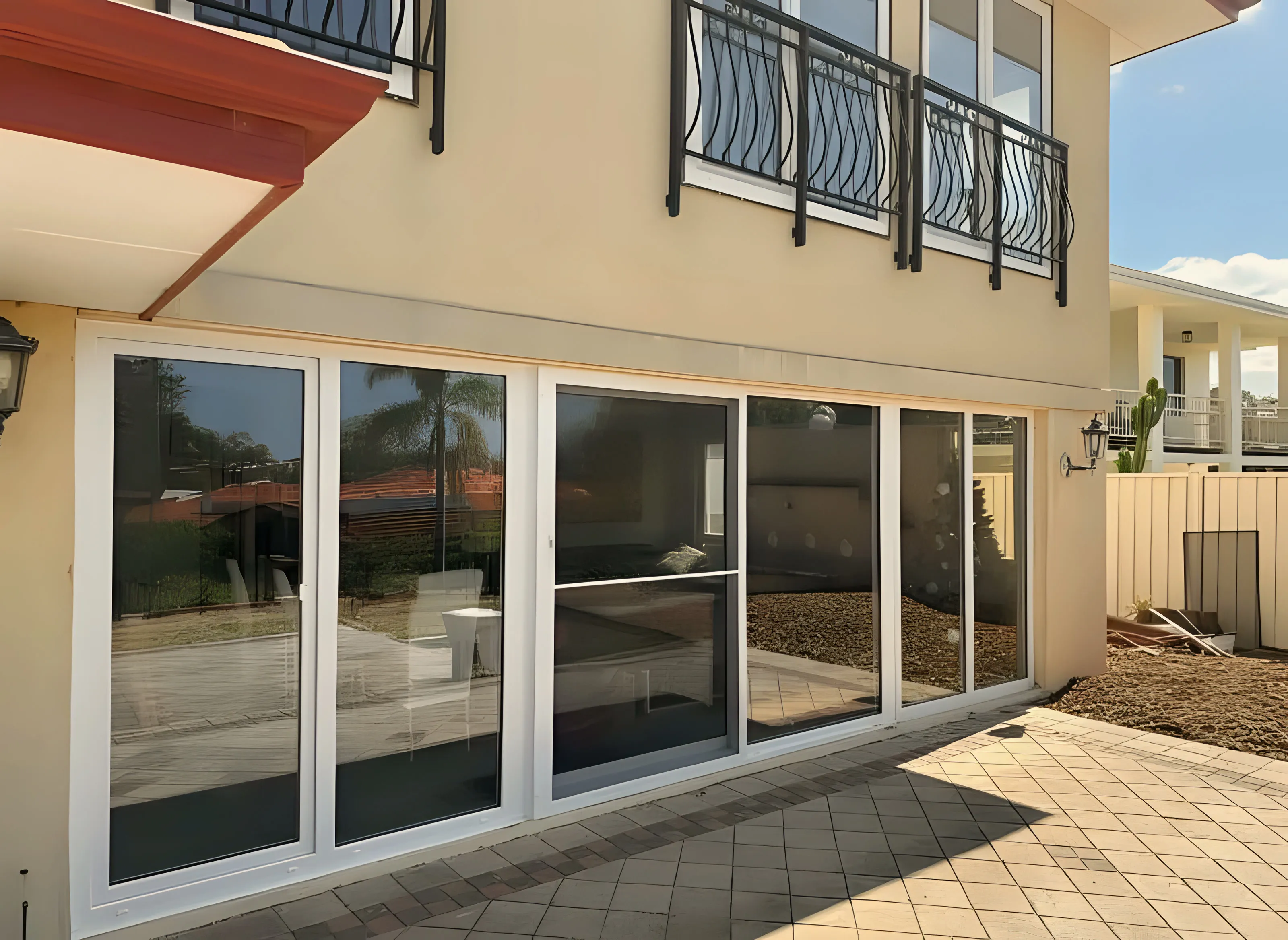 White multi-panel sliding doors beneath wrought-iron balconies