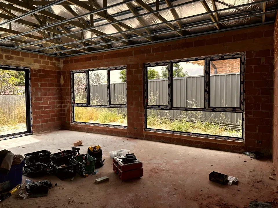 Windows installed in a brick new-build shell with the roof framing still exposed