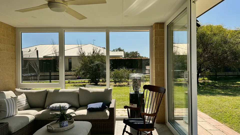 Furnished enclosed patio room with lawn views