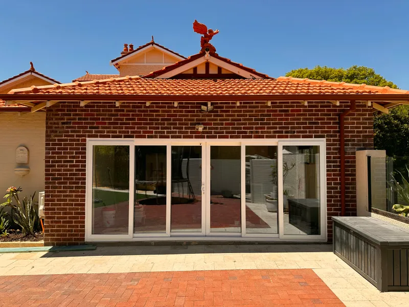 White glazed patio enclosure on heritage red-brick home