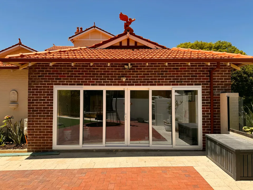 White glazed patio enclosure on heritage red-brick home