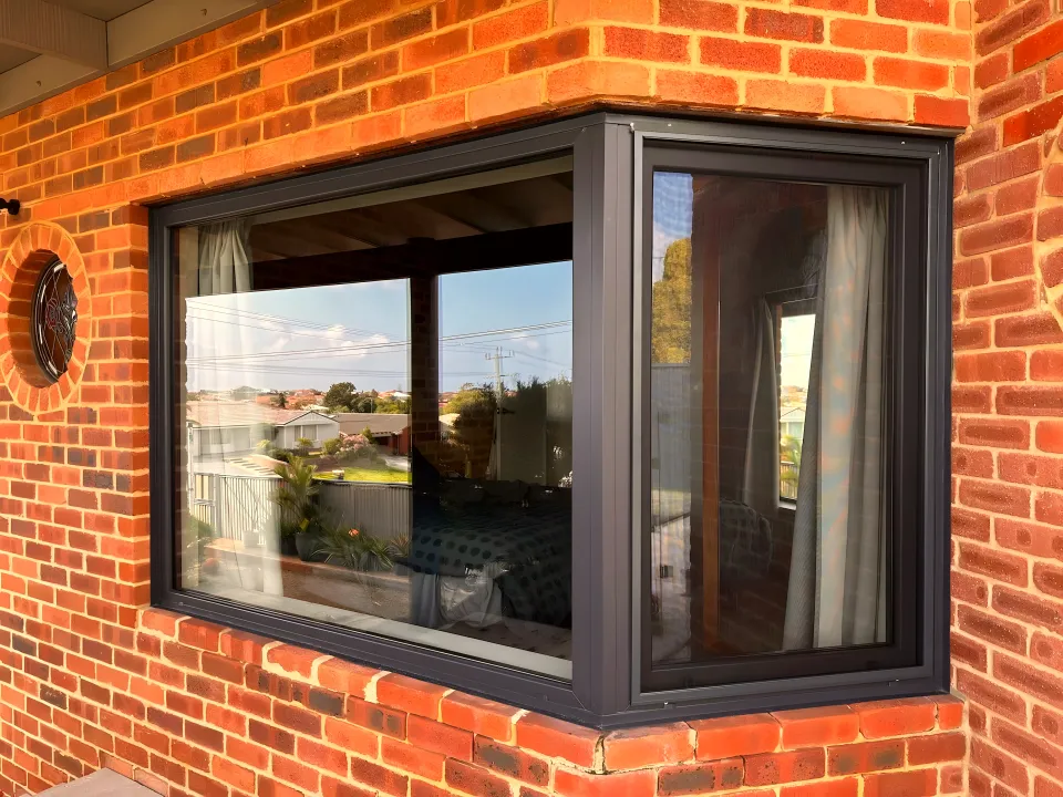 Anthracite retrofit corner window in red brick