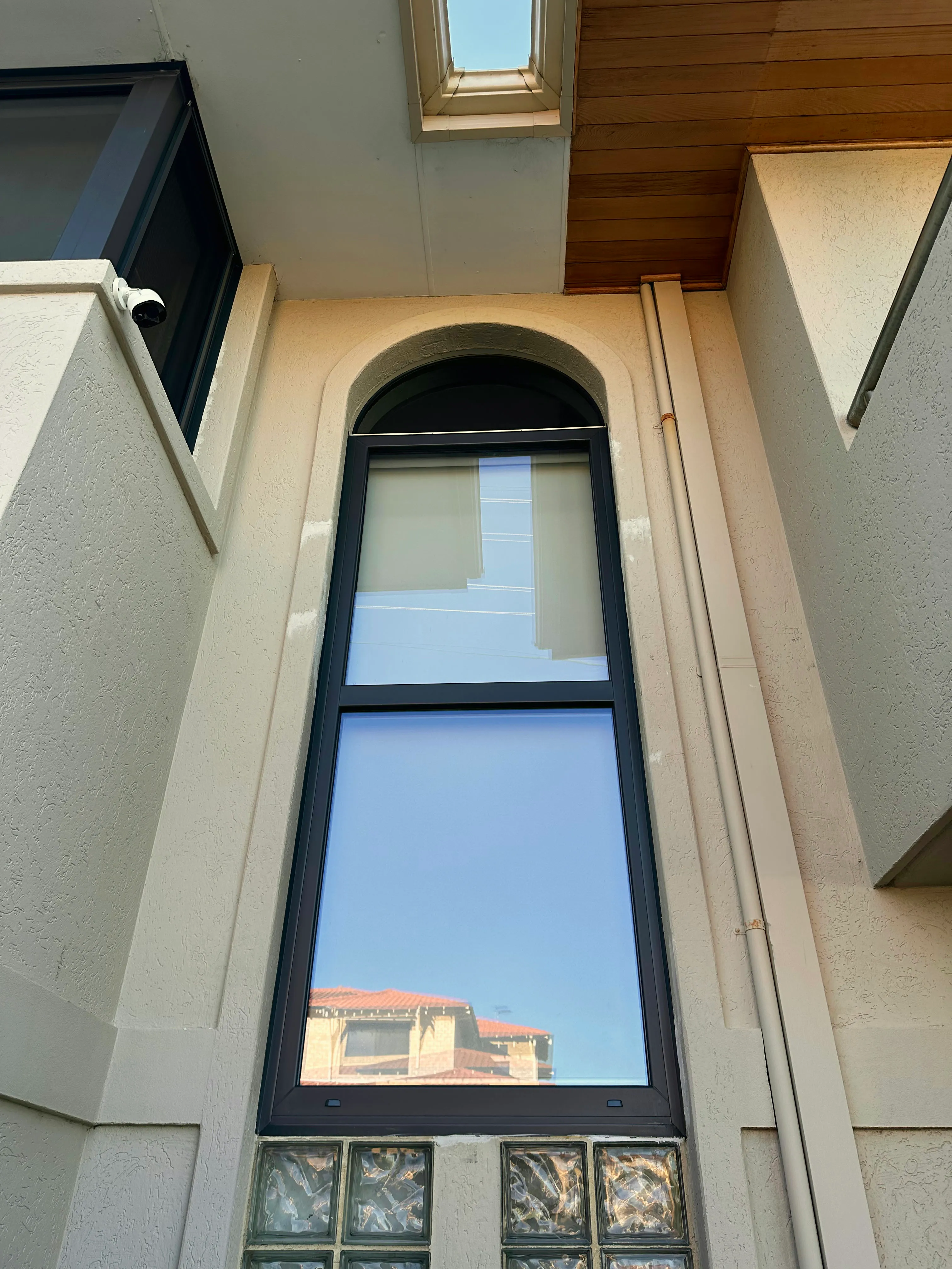Arched double-glazed window in rendered wall