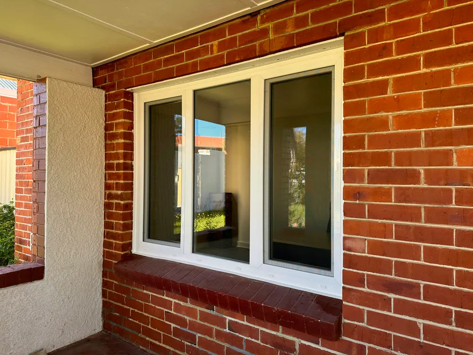 White triple-pane uPVC window in brick wall