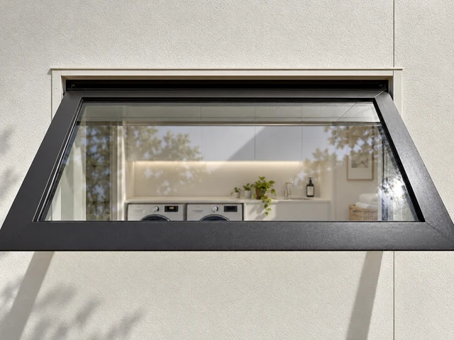 Wide anthracite uPVC awning window opening into a modern laundry
