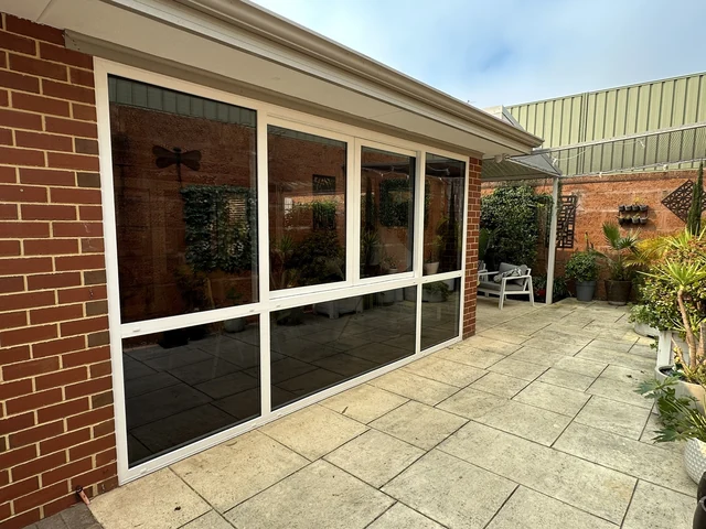 Large white uPVC window wall overlooking an outdoor entertaining area