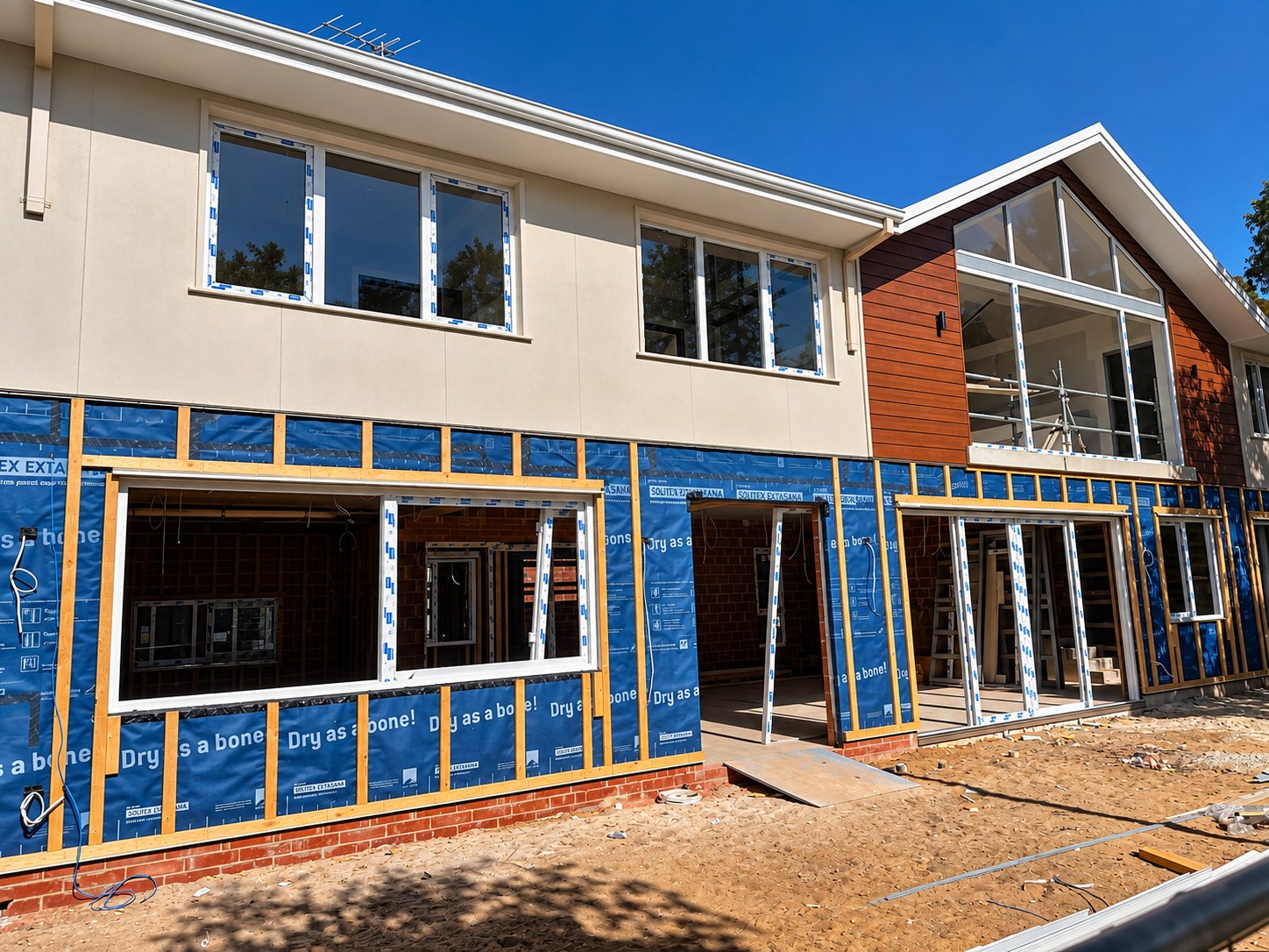 Two-storey new build home under construction with large newly installed windows and doors