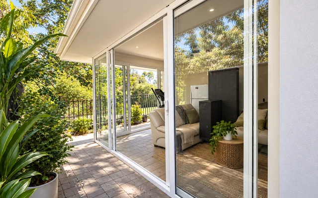 Modern white uPVC sliding patio doors enclosing a bright garden living area