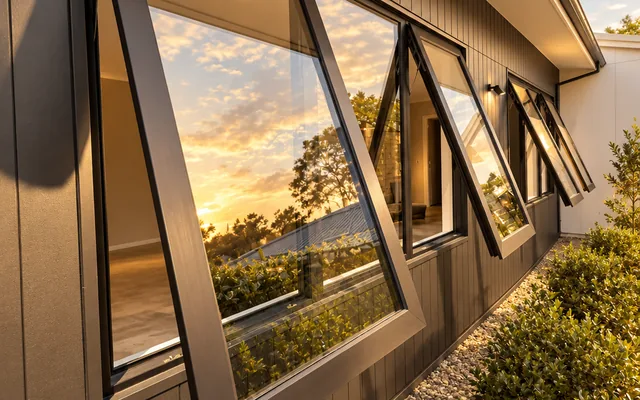 Luxury anthracite awning windows open outward at sunset